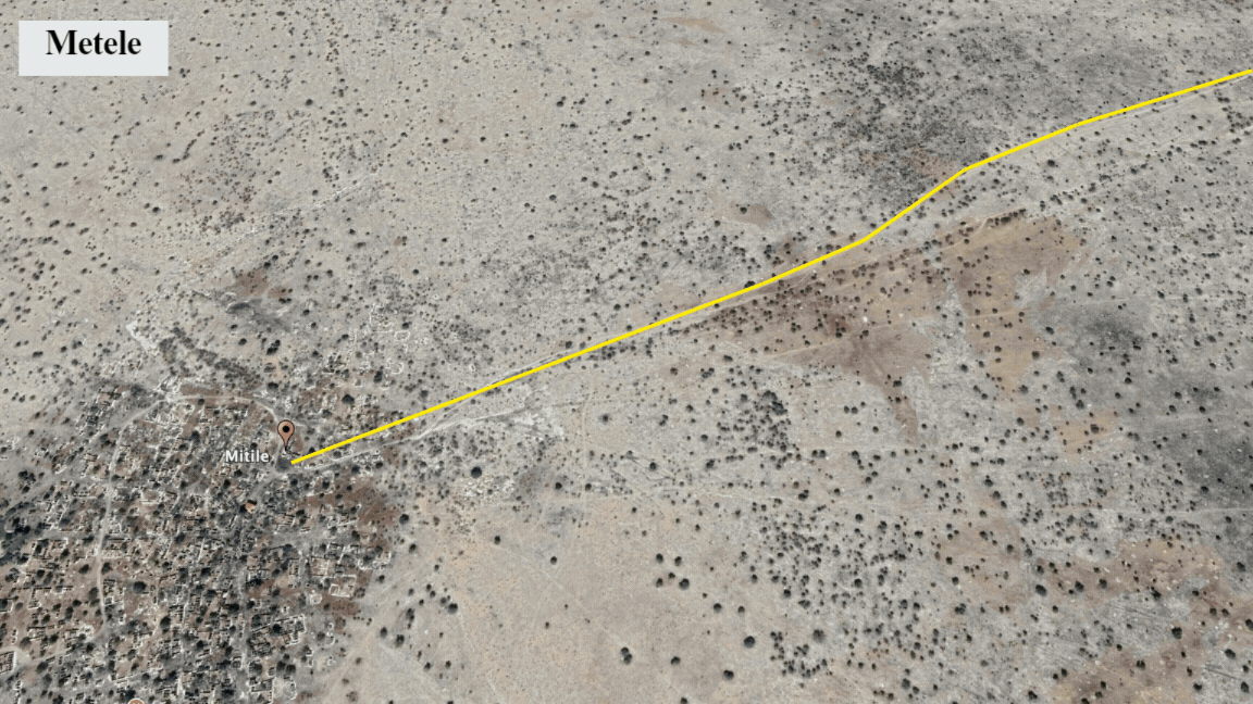 Aerial view showing Metele with a yellow path leading into the desert landscape.
